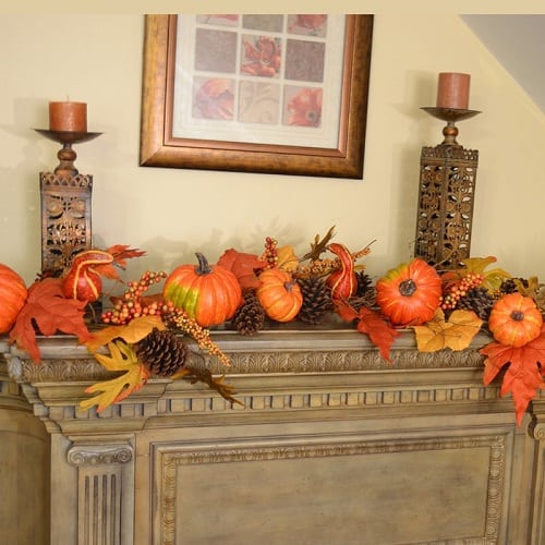 Fall leaf garland decorated with pumpkins and berries. It's the perfect autumn mantel decor idea! 